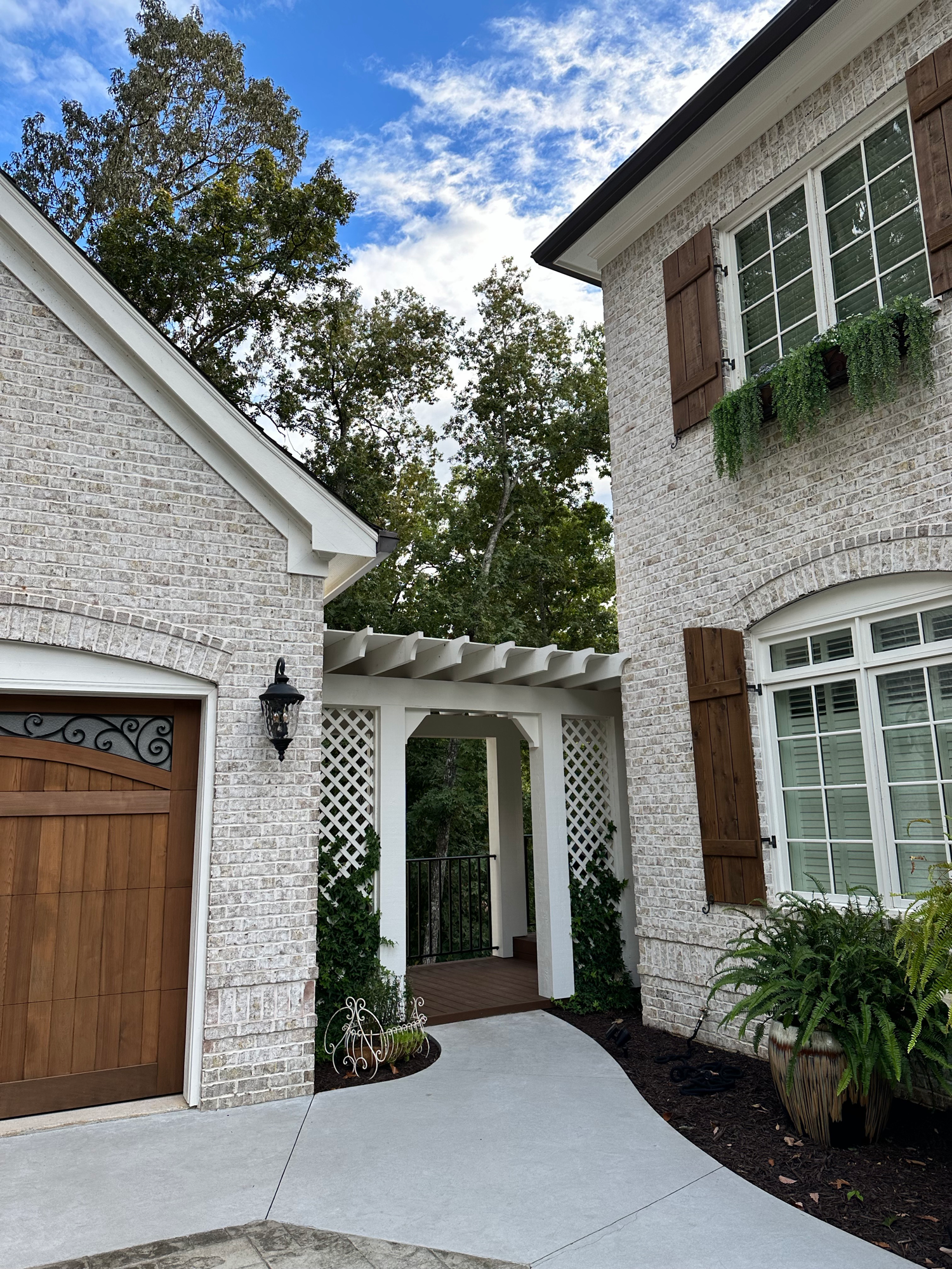 White brick home side with pergola trellis — Lake Lanier by Keystone South Construction