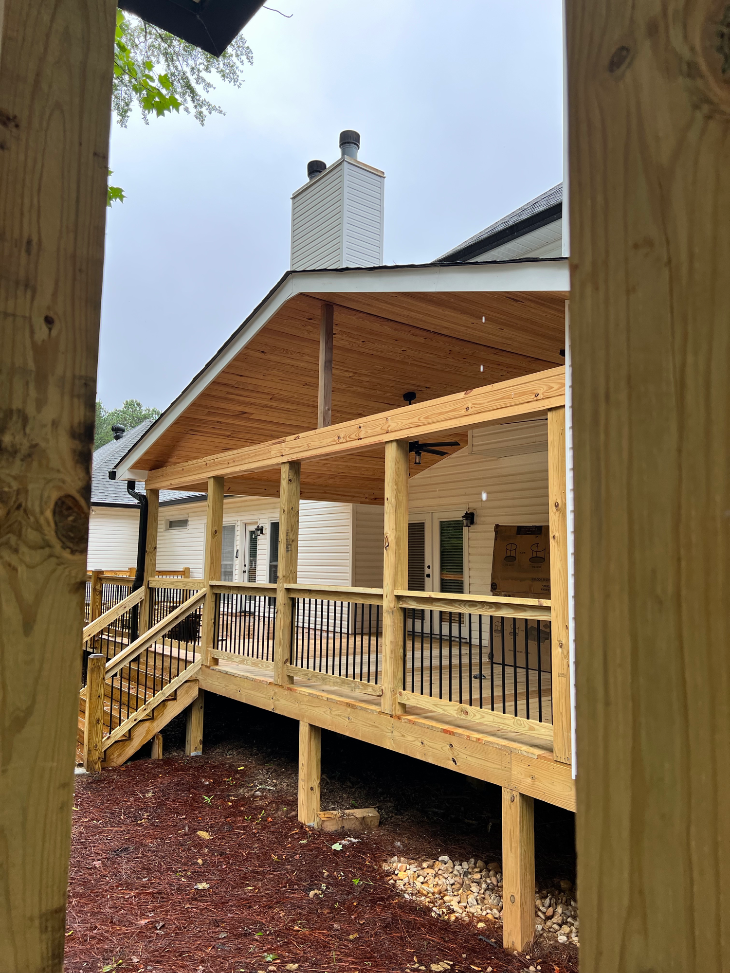 Covered cedar deck with black metal railing — Keystone South Construction Georgia